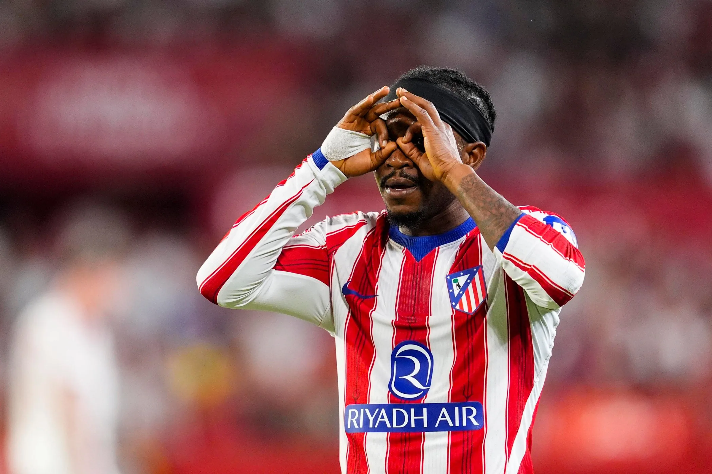 Hráč Atlética oslavuje gól gestom ďalekohľadu, pravdepodobne Ademola Lookman